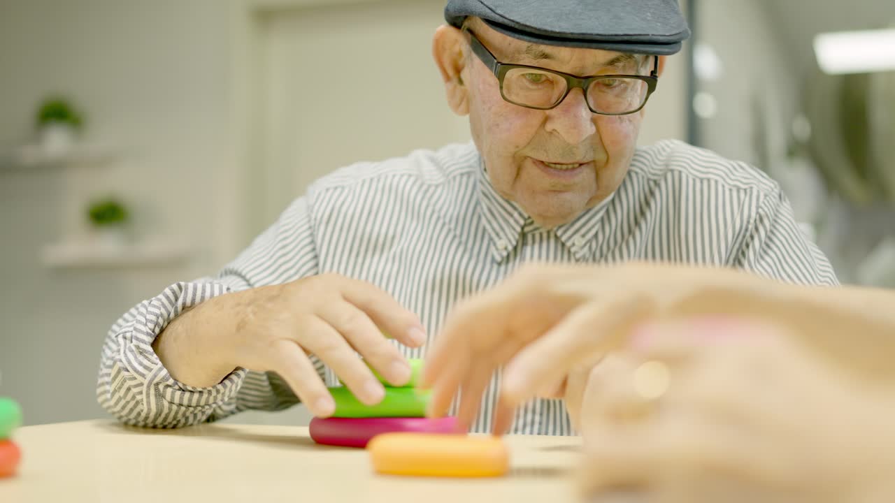 Elderly man playing with stacking toys