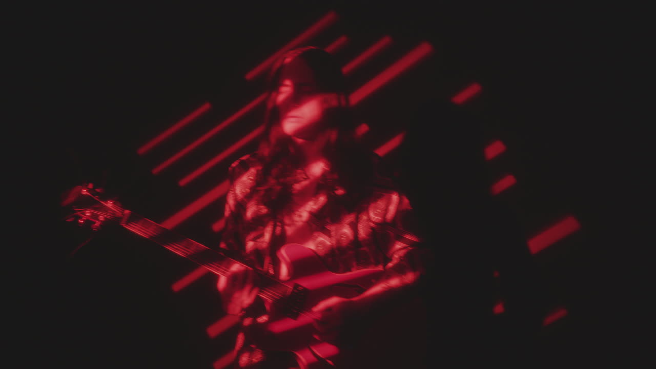 Groovy Indie Musician Playing the Guitar in Red Light Projection