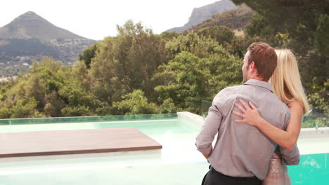 Smiling-couple-pointing-away-and-embracing