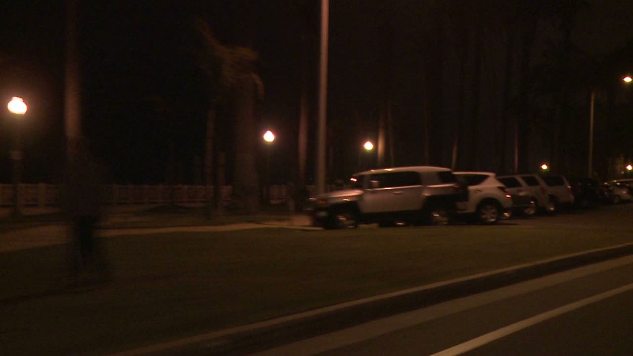 un auto viaja a lo largo de una calle en la noche en santa monica california como se ve a través de la ventana trasera en un ángulo 7