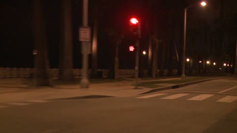 Un-Automóvil-Viaja-Por-Una-Calle-De-Noche-En-Santa-Mónica,-California,-Visto-A-Través-De-La-Ventana-Trasera-En-Un-ángulo-7