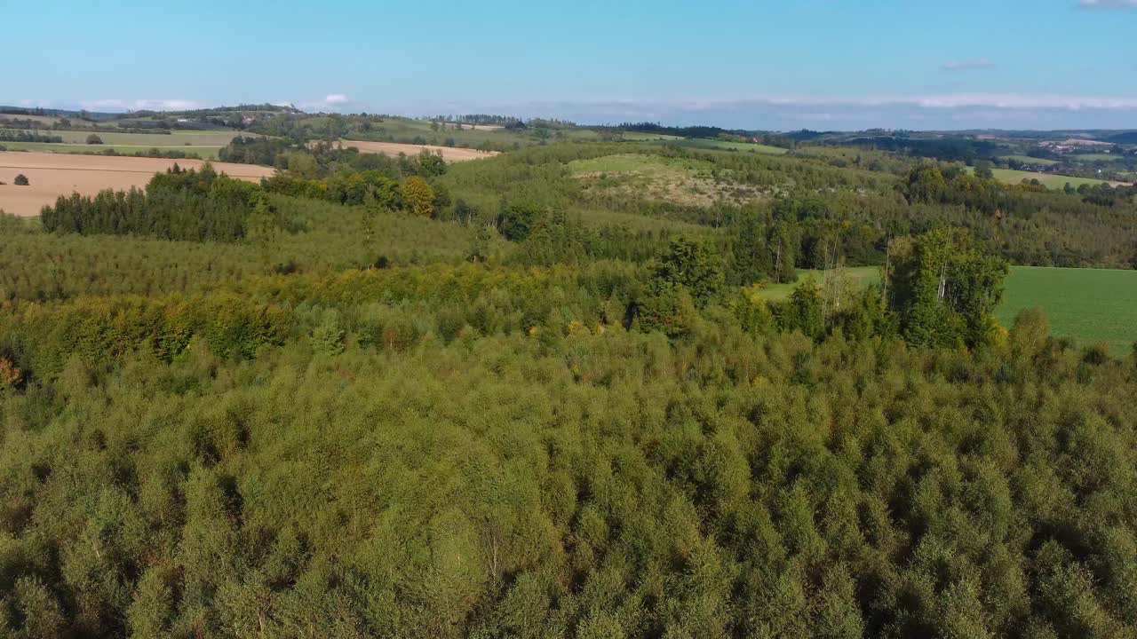 vista aérea de un paisaje checo con bosques y pueblos distantes, volando torcido