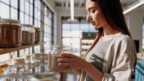 woman shops for bulk grains in an eco-friendly store