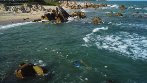 littered garbage floating in the ocean off the shore of a rubbish beach in vietnam