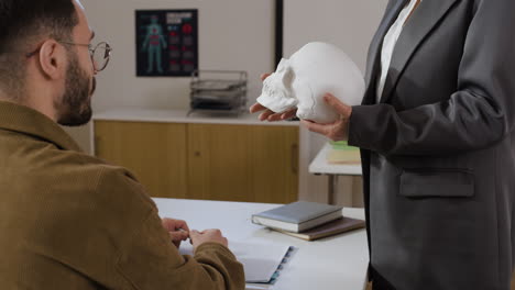 doctor explains anatomy to patient with skull model