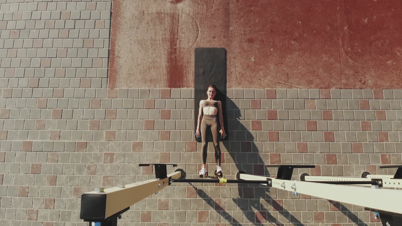 entrenamiento al aire libre. correas de suspensión. aero vista superior. mujer joven atlética está haciendo ejercicios de resistencia de todo el cuerpo usando cuerdas en bucle trx, en el campo deportivo al aire libre de la ciudad, gimnasio. entrenamiento de fitness al aire abierto. concepto de estilo de vida saludable. entrenamiento deportivo matutino en el