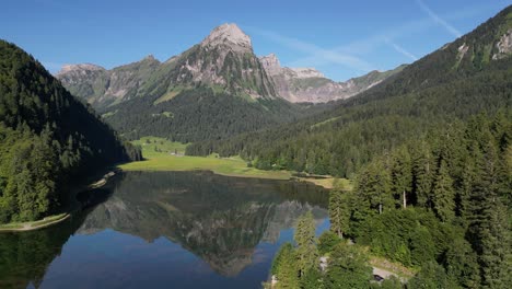 drone disparó el reflejo de la montaña en el agua tranquila del lago rodeado de bosque de pinos en suiza obersee nafels tierras altas en verano día soleado cielo azul y paisajístico maravilloso fondo verde viaje nadar