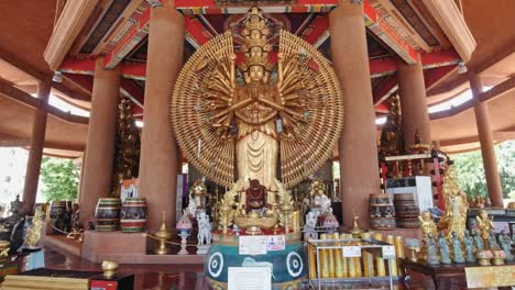 golden buddha inside guanyin temple in bangkok, thailand with a pan up of the beautiful architecture and decorations