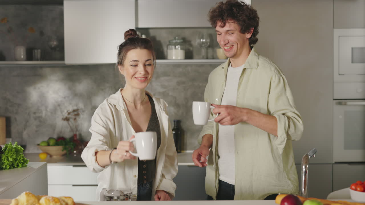 Happy couple preparing morning coffee or tea in a modern kitchen