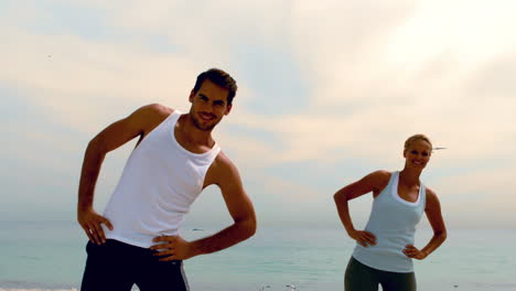 friends exercising together on the beach