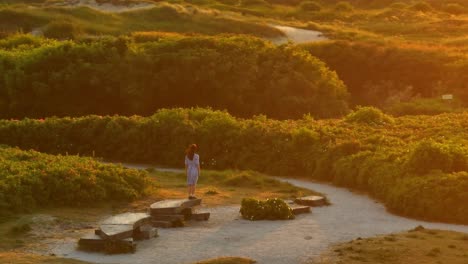 girl in a purple dress at sunset on a hilly landscape