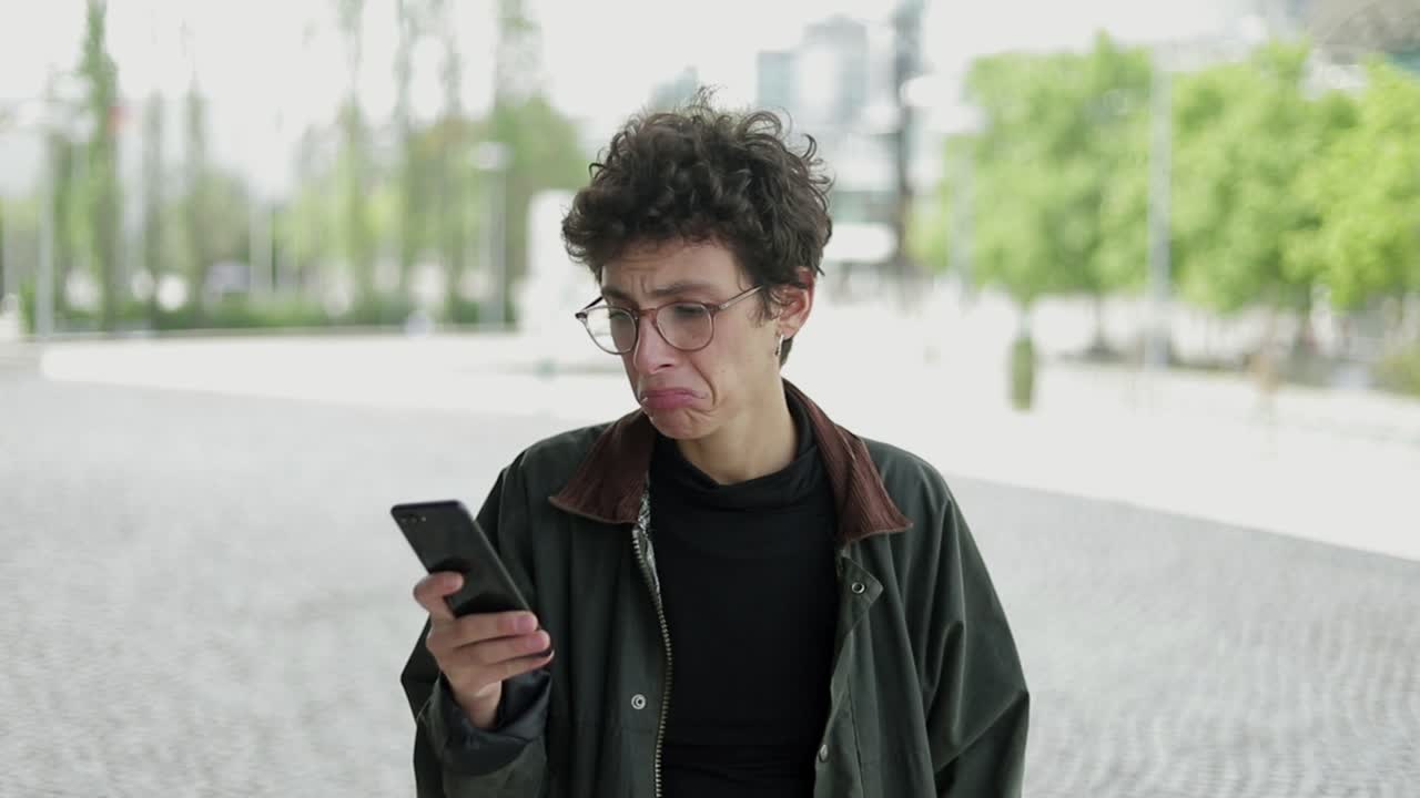 Donna dubbiosa che usa il cellulare all'aperto