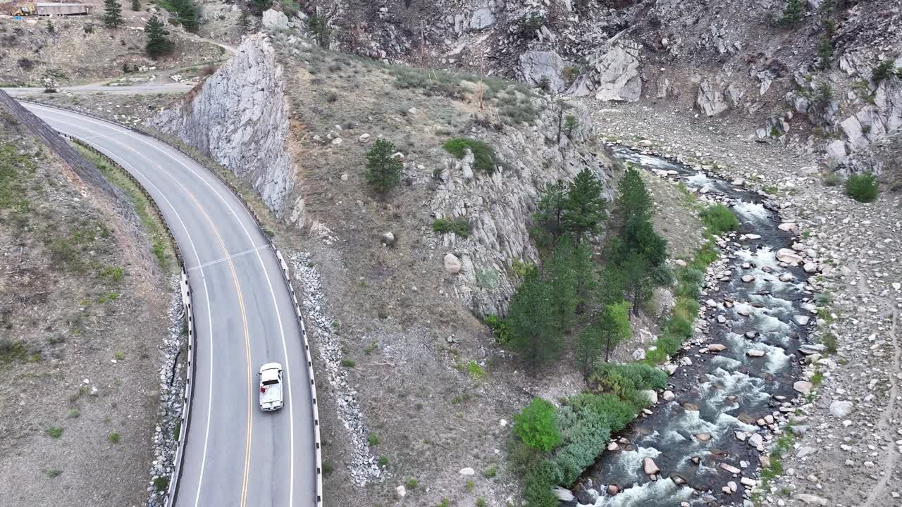 River and highway. A pickup truck drives through the frame. 4k aerial.