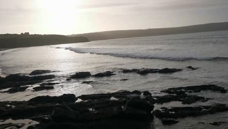 The-tide-coming-in-across-a-sand-and-pebble-beach-in-Broad-Haven,-West-Wales-in-early-evening