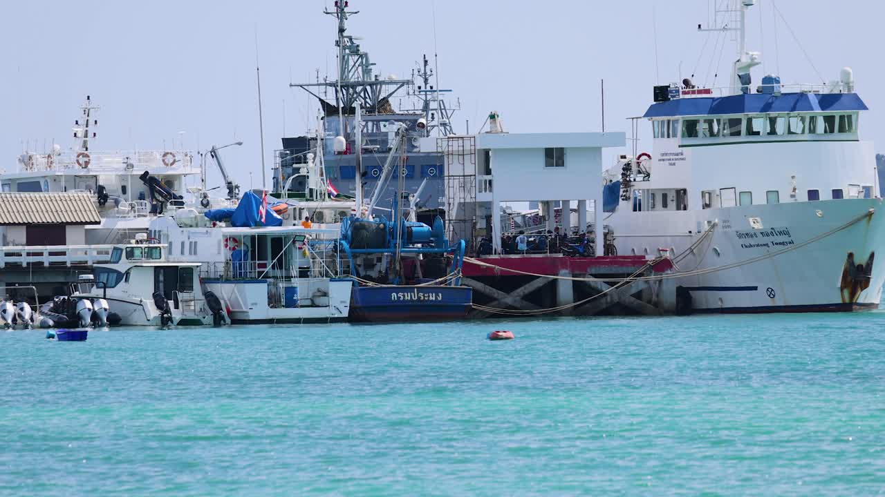 A marine research vessel docked in Phuket, Thailand, under clear skies with calm turquoise waters