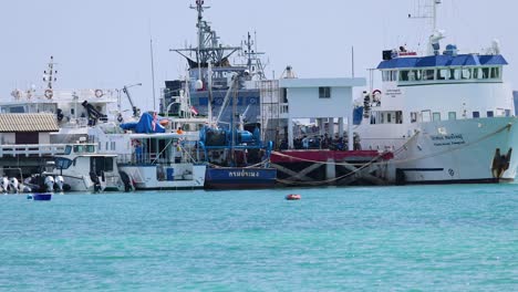a marine research vessel docked in phuket, thailand, under clear skies with calm turquoise waters