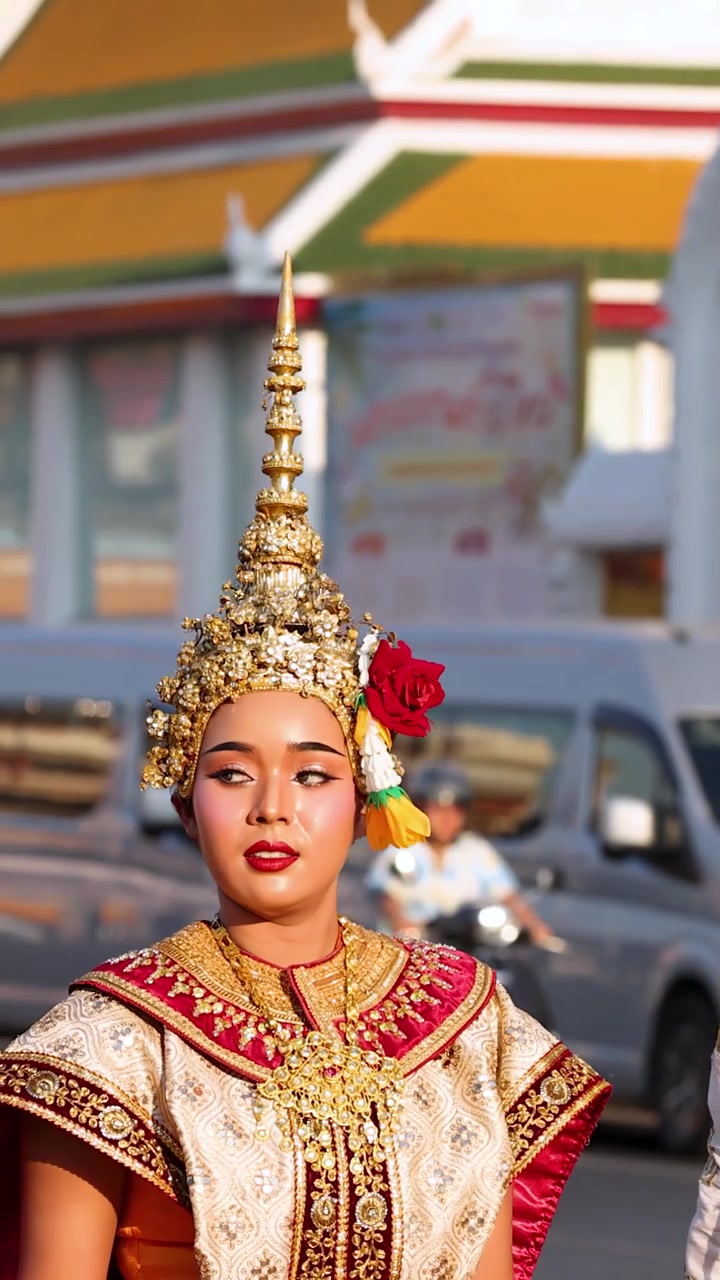 Danzatori in elaborati costumi dorati eseguono movimenti tradizionali Khon all'aperto durante la luce del tramonto.