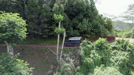 Tiro-De-Drone-De-Profundidad-Con-Kayak-Claro-En-Camino-De-Tierra-Estrecha-En-El-Bosque,-Mahe-Seychelles