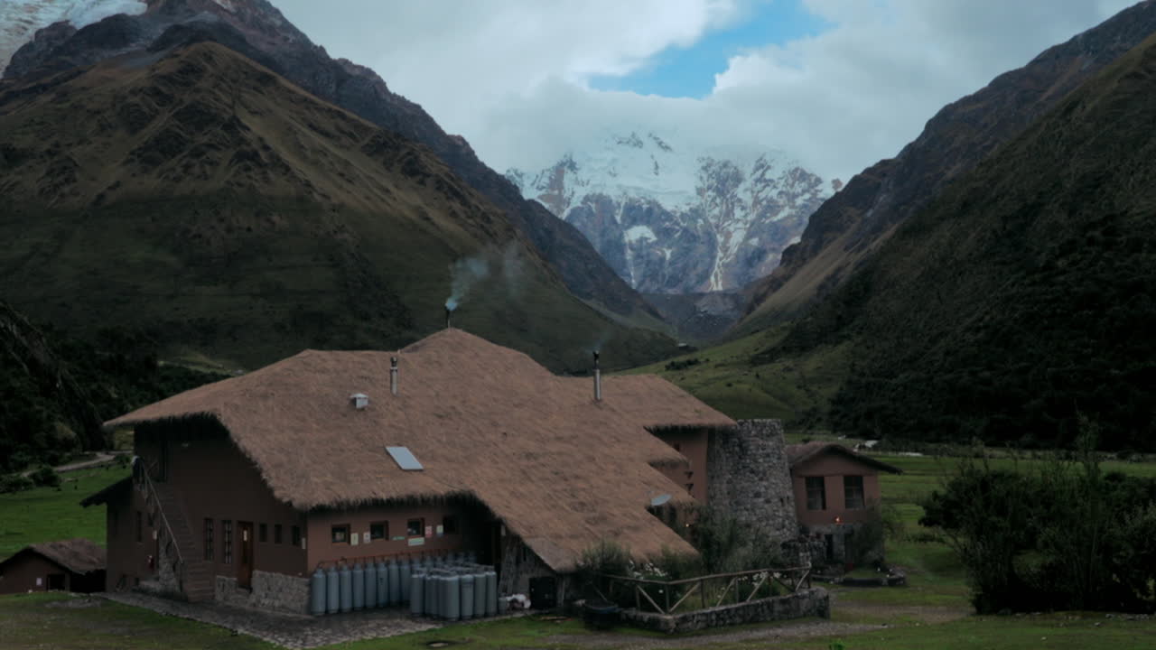 Herauszoomen von einer Hütte zum verschneiten Salkantay Berg in Cusco, Peru