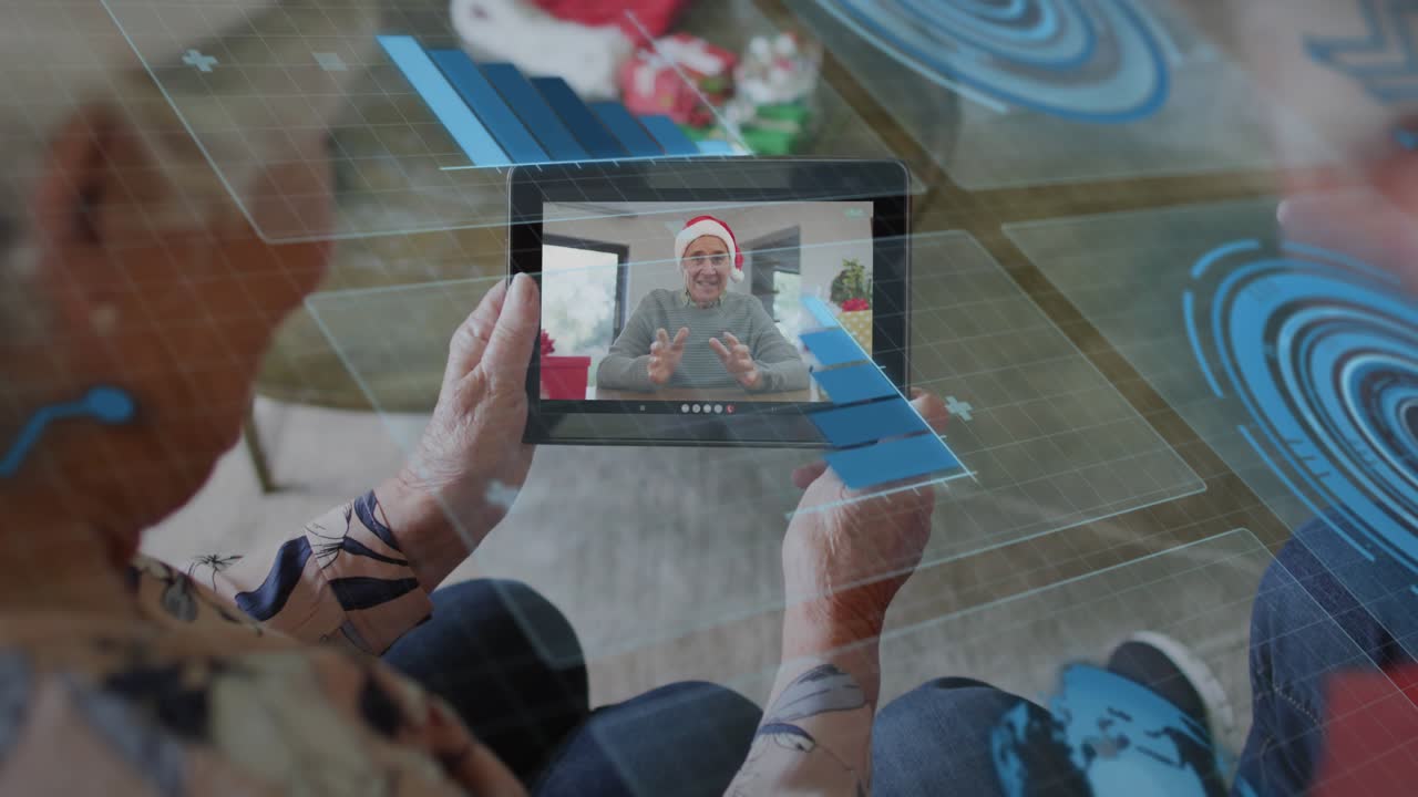 Seniors holding tablet watching Santa speaking, holo panels animating as tech Xmas call starting