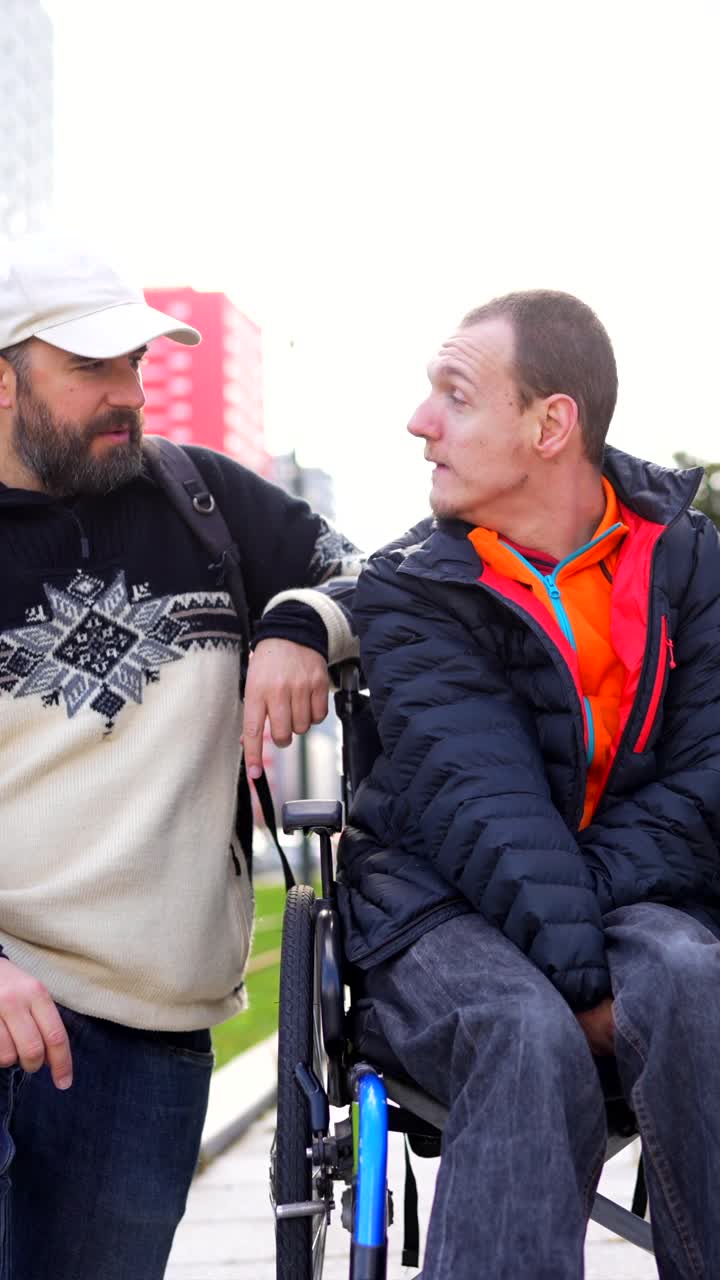 Man pushing a person in a wheelchair