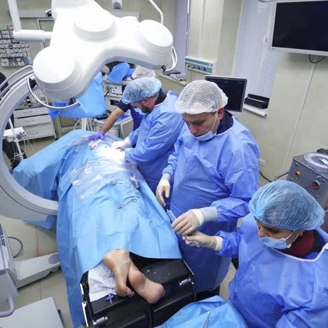surgeons team performing operation. surgical team in scrubs performing surgery on patient