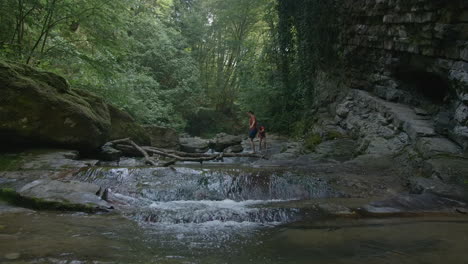 family hiking through a forest creek