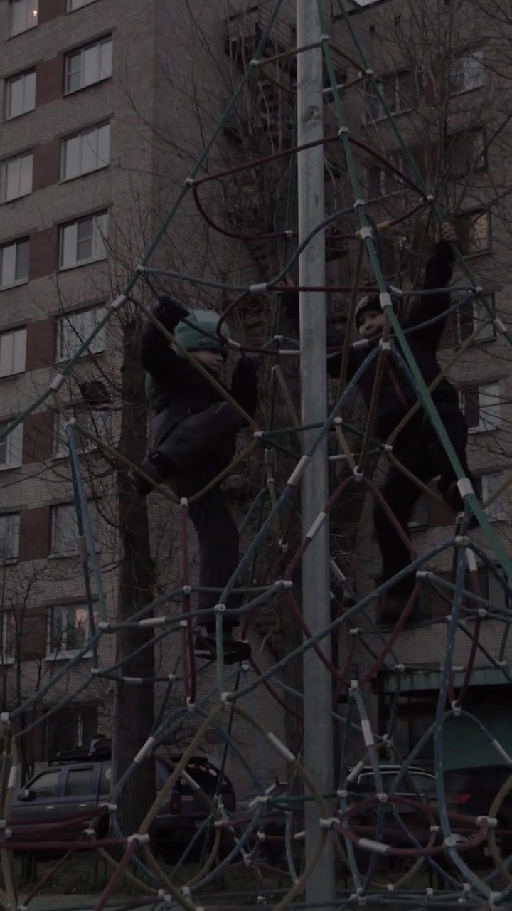 Active children climbing rope web on playground