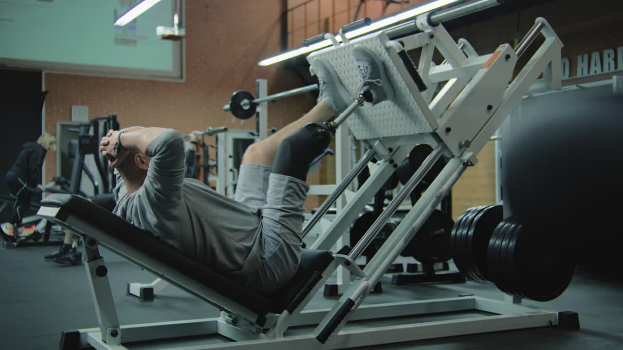 Man with prosthetic leg using leg press machine in gym
