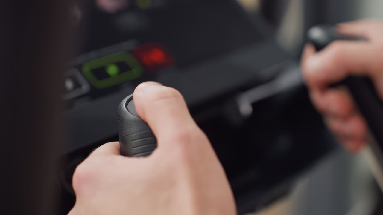 Firm grip with both hands of man on movable handle pressing control knob to adjust speed on elliptical console in bright modern gym under natural light showcasing focused intensity adjustment