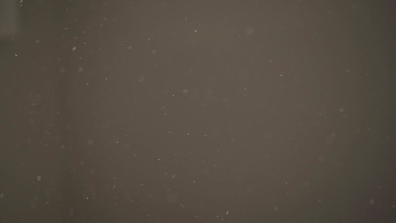 어두운 방에서 움직이는 느린 동작의 먼지 입자
