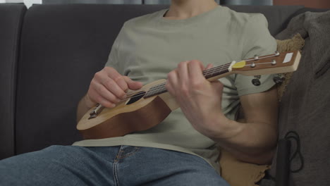 Close-up-view-of-unrecognizable-man-sitting-on-a-sofa