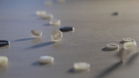 slow motion of close-up of various colorful buttons on a table. different colored buttons made of plastic. sewing supplies, accessories for clothes, sewing thread, sewing buttons,textile accessory