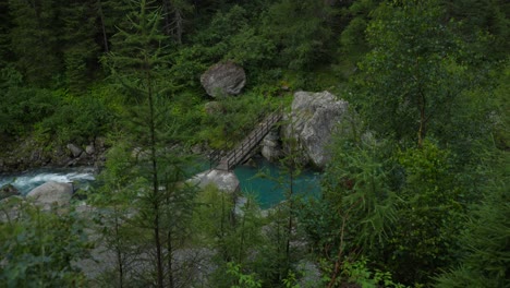 Wooden-Bridge-Over-Rapids-In-The-Forest-Mountains-Of-Lago-Lagazzuolo-In-Valmalenco,-North-of-Italy