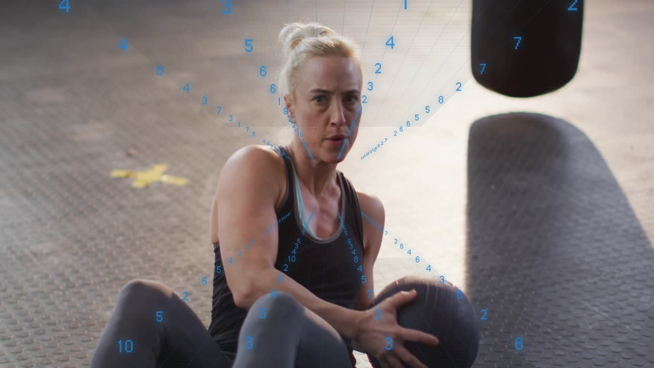 Woman holding med ball, performing twists in gym while blue numeric overlay counting reps for core