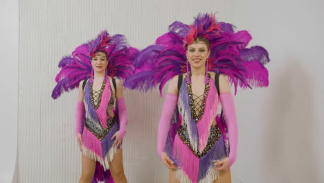 two female dancers in pink and purple gowns doing cabaret dance