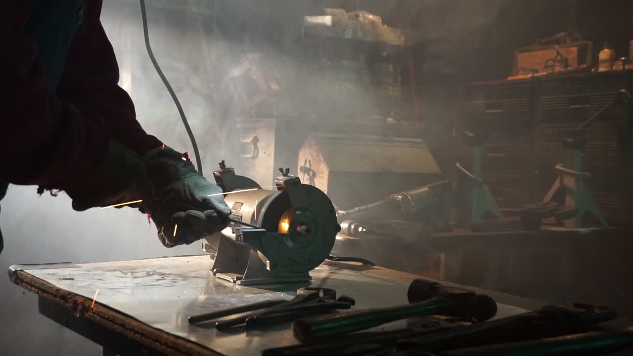 la varilla de metal se muele en una amoladora de banco