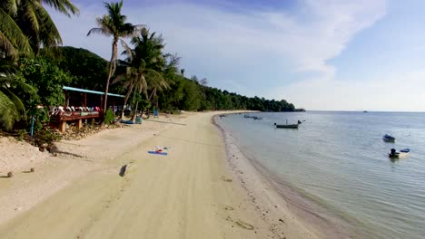 Panning-from-below-going-up,-and-slightly-tilting-the-aerial-drone-shot-to-get-a-better-view-of-Haad-Yao-Beach-in-Koh-Phangan-in-Thailand