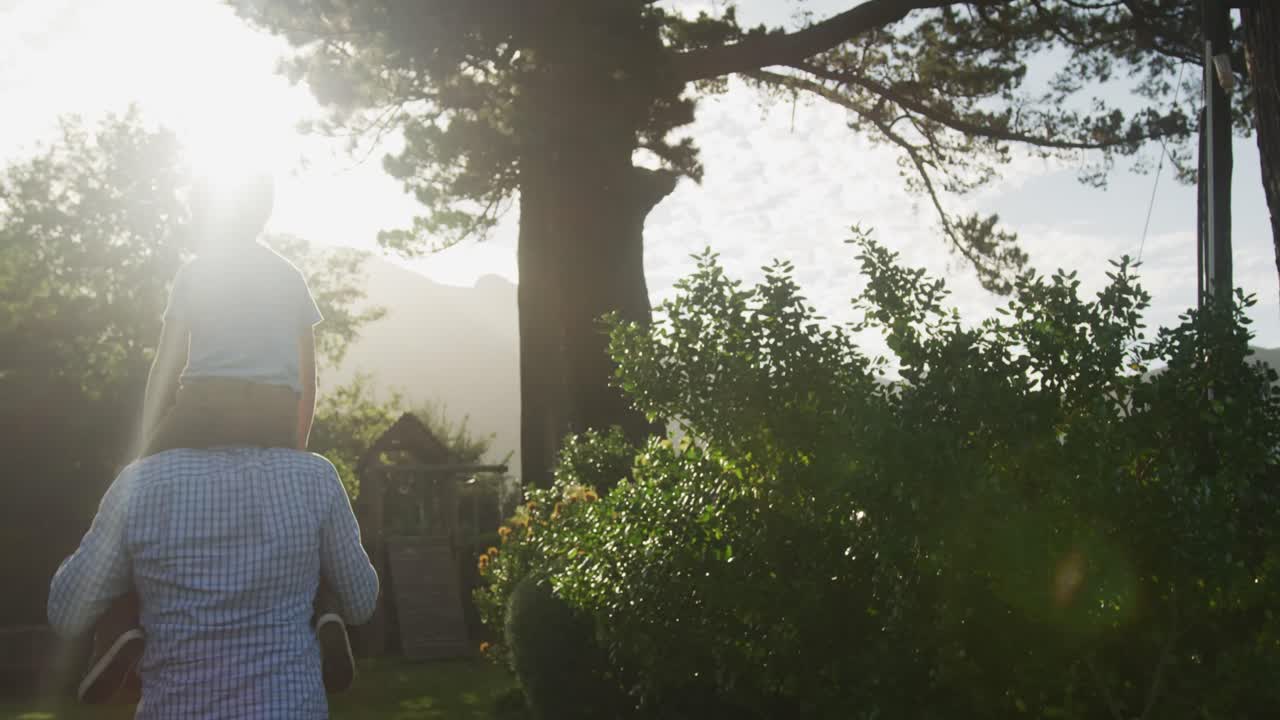 고위 백인 남성과 그의 손자가 정원에서 시간을 보내고 있습니다.