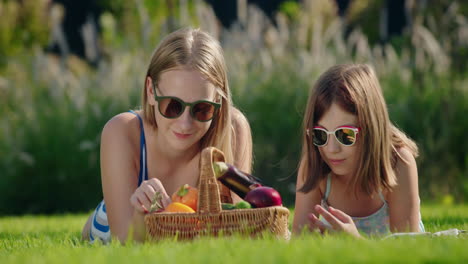 dos amigos en un picnic, cerca de ellos una canasta de verduras frescas