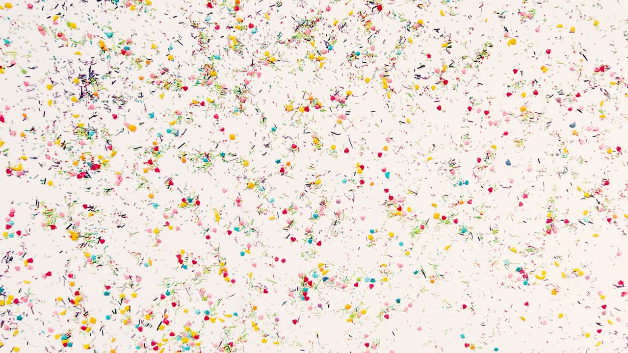 손은 베이킹 스프링클의 배경에 새겨진 글자를 위해 둥근 프레임을 만니다. 타임 스 비디오, 16x9 형식.