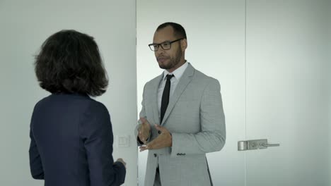 two business people having conversation in corridor.