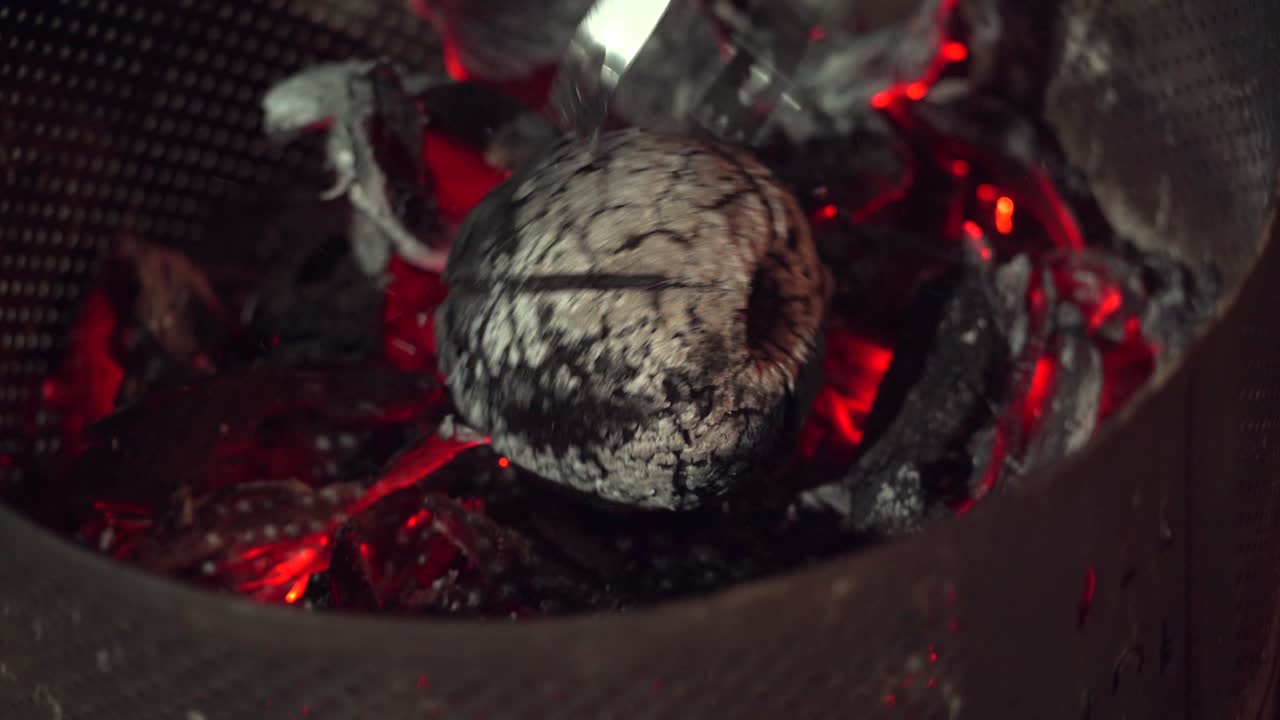 frutas de pan asadas en fuego abierto, hombre girando las frutas de pan para comprobar el asado, comida tradicional de las seychelles, mahe, seychelles 4k 24fps 005