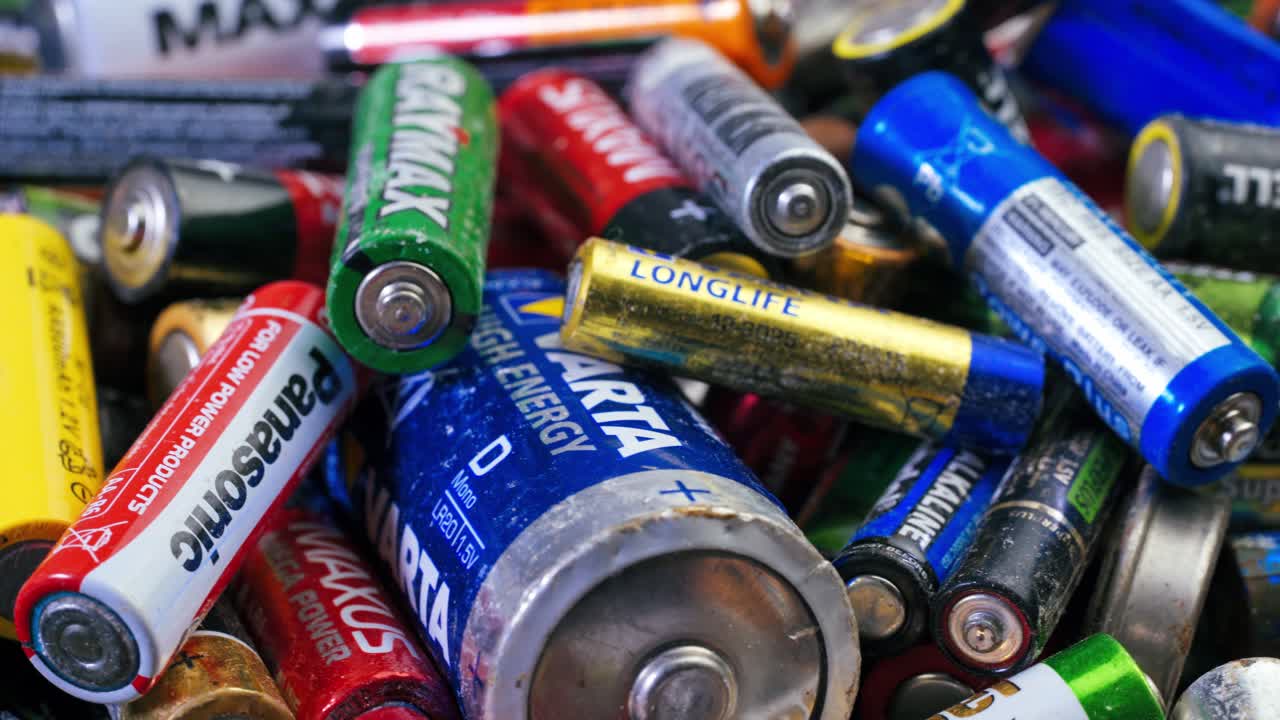 Used batteries from different manufacturers, waste, collection and recycling, high danger for the environment. Batteries background