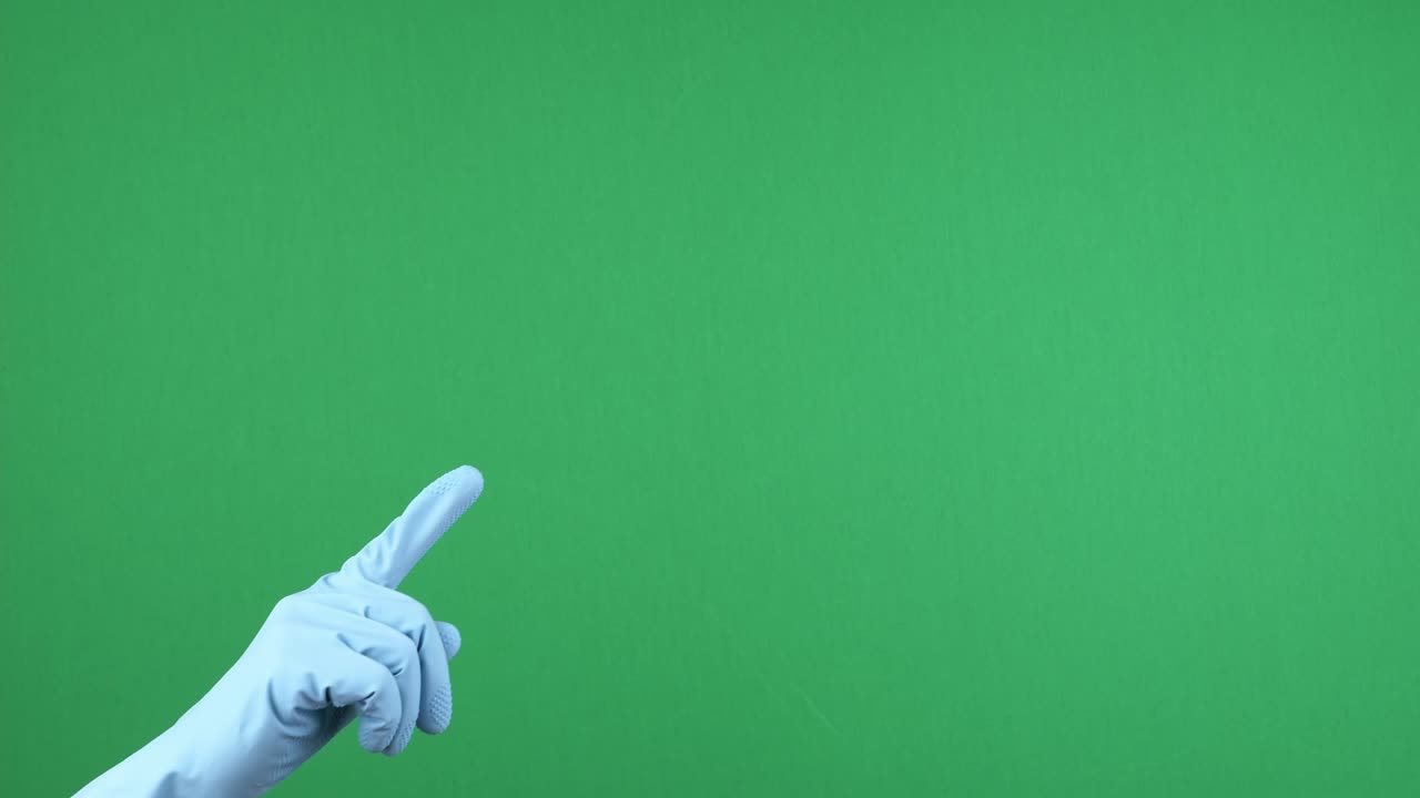 mano femenina con guante de goma de protección azul apuntando hacia arriba con el dedo sobre la llave de croma vacía fondo de pantalla verde. gesto de la mano. video 4 k