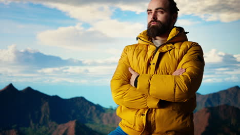 un excursionista se encuentra victorioso en un pico de montaña con los brazos levantados en triunfo