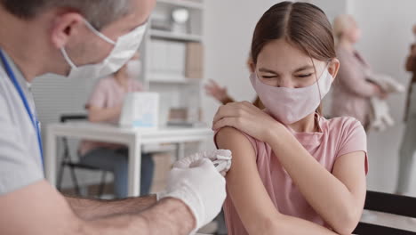 girl getting painful injection on shoulder