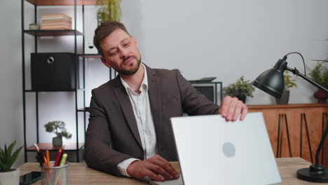hombre sonriente cerrando el negocio de computadoras portátiles después de terminar el trabajo en línea trabajo remoto desde la oficina de casa