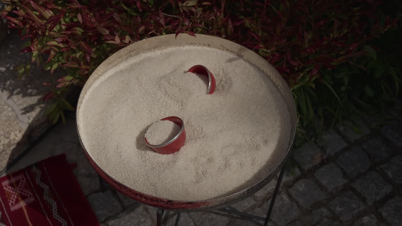 Closeup of rice tray with red scoops placed outdoors