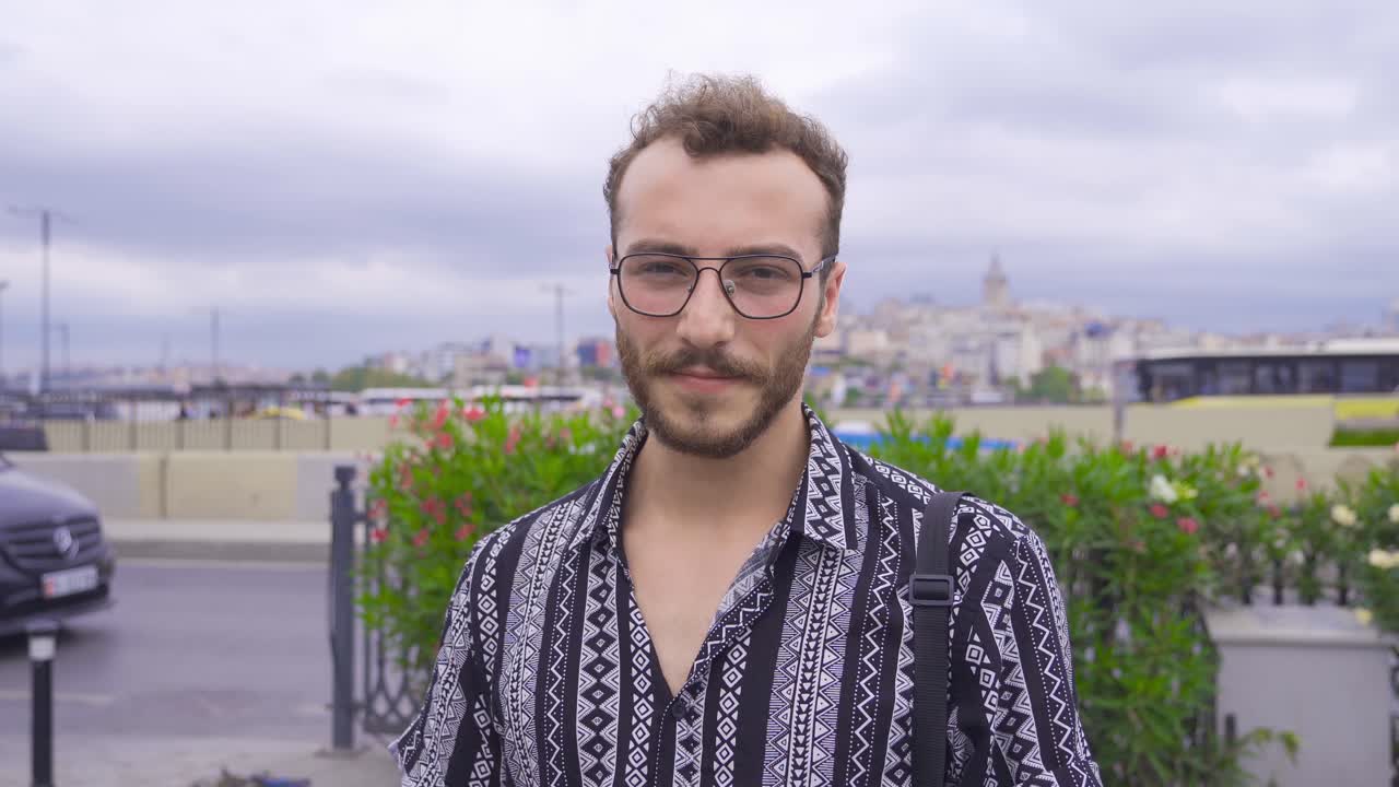 un joven sonriendo a la cámara.